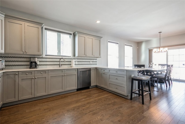 kitchen with light countertops, a sink, decorative light fixtures, and gray cabinetry