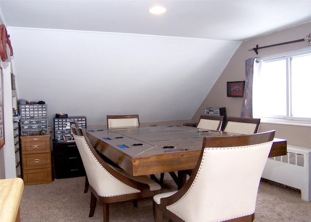 carpeted dining area with radiator heating unit and vaulted ceiling