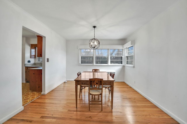 dining area with a notable chandelier and light wood-type flooring