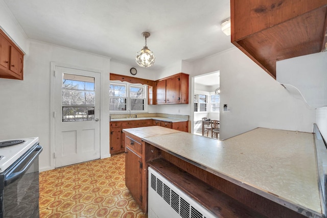 kitchen with decorative light fixtures, range with electric cooktop, and a healthy amount of sunlight