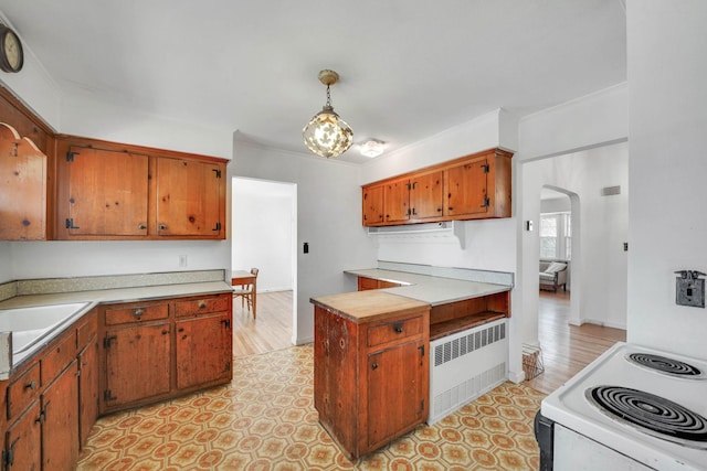 kitchen with sink, pendant lighting, electric range, radiator, and ornamental molding