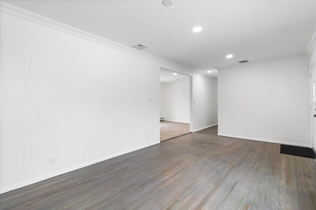 empty room featuring baseboards, dark wood-style flooring, visible vents, and crown molding