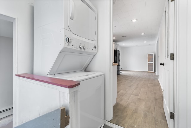 washroom with a baseboard radiator, recessed lighting, laundry area, stacked washer / drying machine, and light wood finished floors