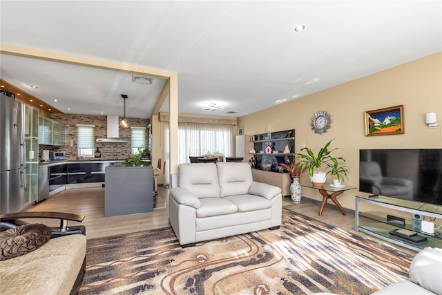 living room with visible vents, wood finished floors, and recessed lighting