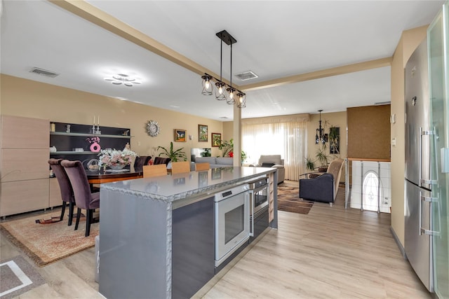 kitchen featuring open floor plan, visible vents, and decorative light fixtures