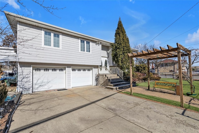 view of front of home with an attached garage, a pergola, and concrete driveway