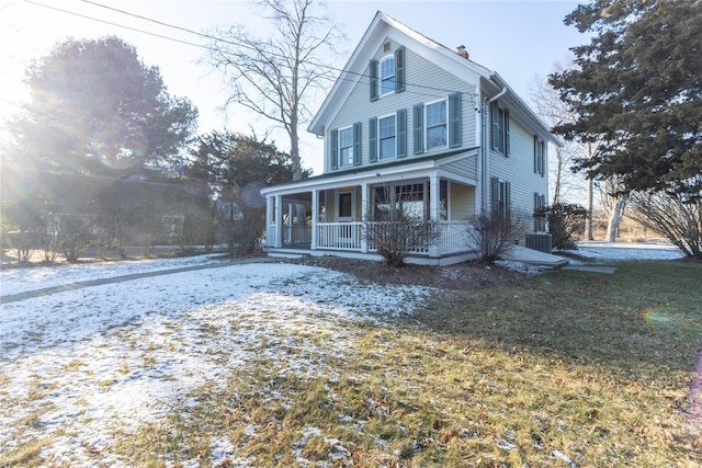 view of front of house with central AC, a front yard, and covered porch