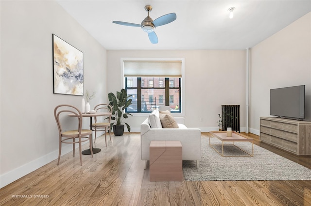 living room featuring ceiling fan and light hardwood / wood-style flooring