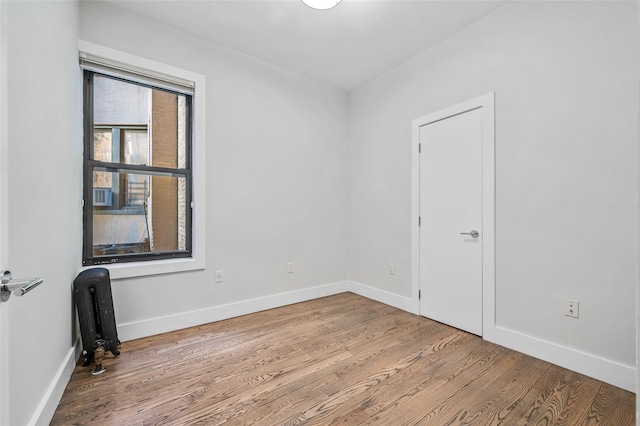 empty room with radiator and light hardwood / wood-style floors