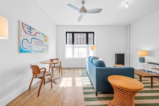 living area with ceiling fan, light wood-style flooring, and baseboards