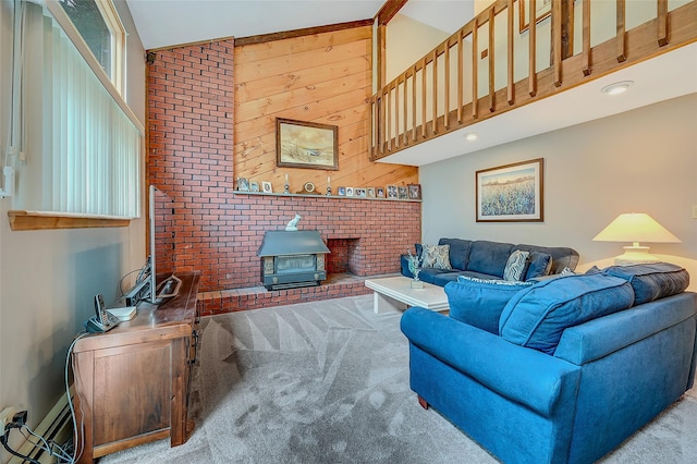 carpeted living room featuring a high ceiling, brick wall, a wood stove, and wood walls