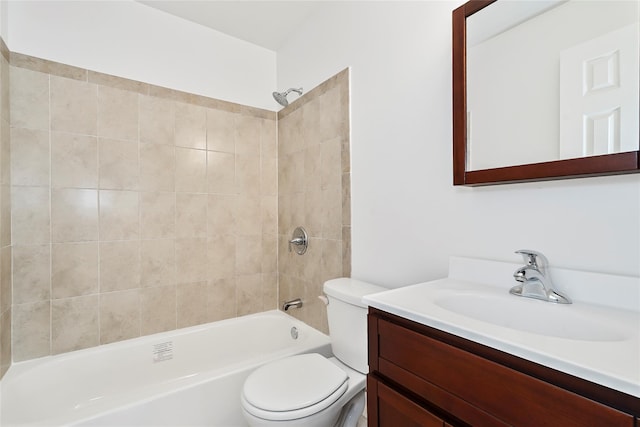 full bathroom featuring tiled shower / bath, vanity, and toilet