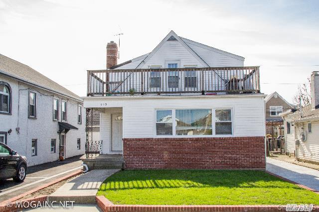 view of front of house featuring a balcony and a front lawn