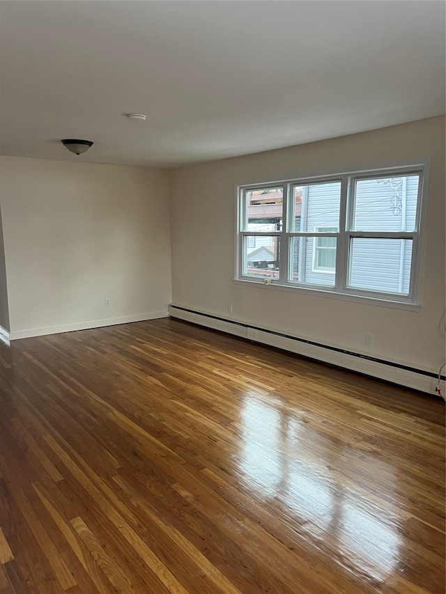 unfurnished room with a baseboard radiator and hardwood / wood-style floors