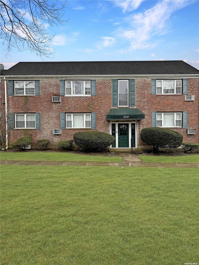 view of property with brick siding and a front yard