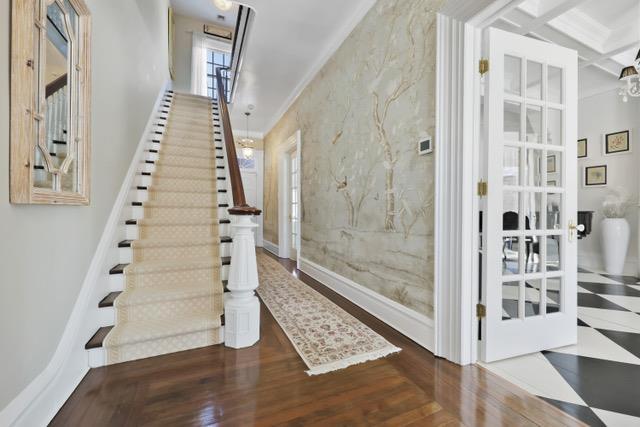 entrance foyer with crown molding, wood finished floors, coffered ceiling, baseboards, and stairs