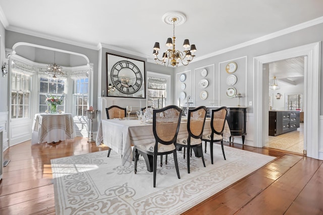 dining area featuring a chandelier, wood-type flooring, and plenty of natural light