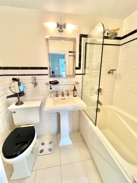 full bathroom featuring shower / bathtub combination, toilet, tile walls, and tile patterned floors