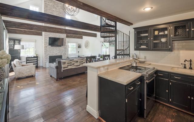 kitchen featuring electric range, dark cabinets, a peninsula, a fireplace, and a sink