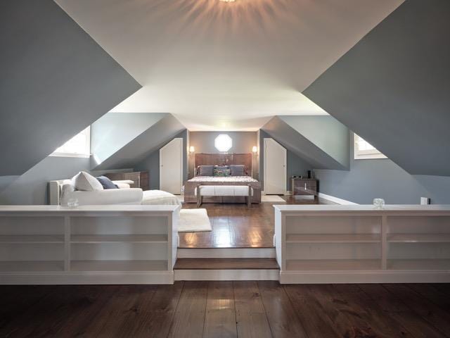 unfurnished bedroom featuring lofted ceiling and hardwood / wood-style floors