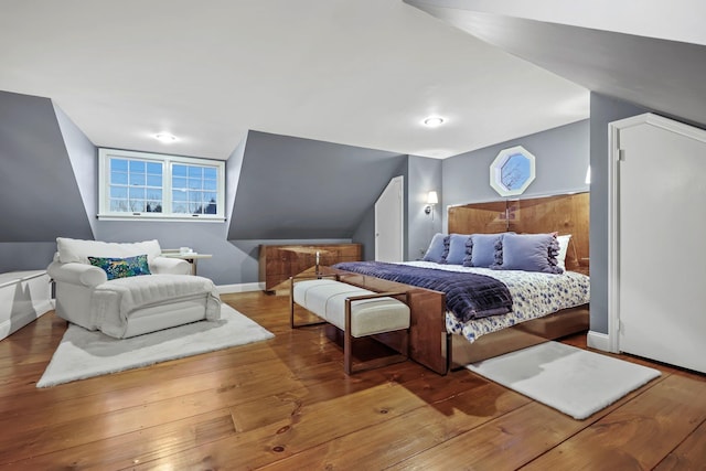 bedroom featuring vaulted ceiling, baseboards, and hardwood / wood-style flooring