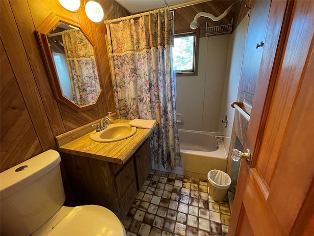 full bathroom featuring vanity, wooden walls, toilet, and shower / bath combo with shower curtain