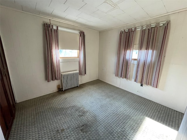 empty room with radiator and carpet floors