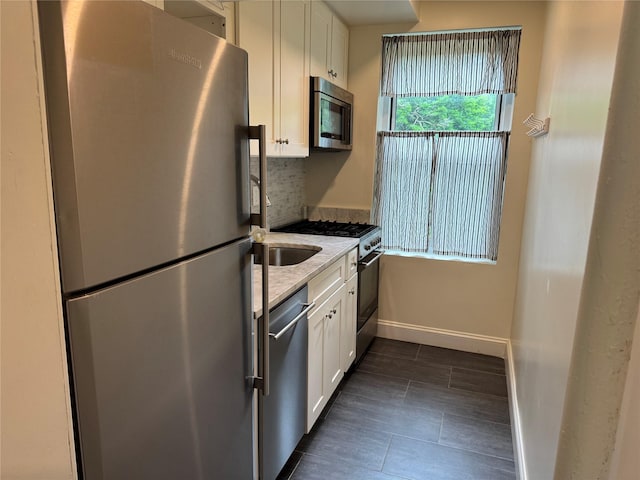 555 Broadway Ave Unit 1H, Hastings-On-Hudson, NY 10706 - kitchen featuring stainless steel appliances, white cabinetry, light stone counters, and decorative backsplash