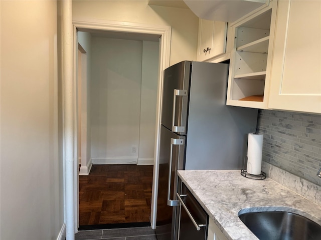 555 Broadway Ave Unit 1H, Hastings-On-Hudson, NY 10706 - kitchen featuring backsplash, appliances with stainless steel finishes, light stone counters, and white cabinets