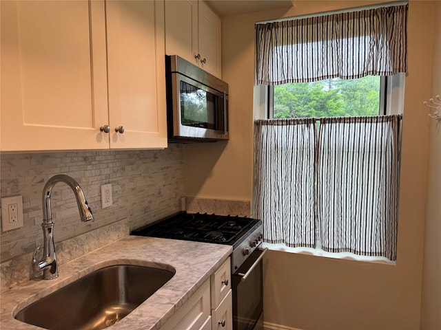 555 Broadway Ave Unit 1H, Hastings-On-Hudson, NY 10706 - kitchen featuring stainless steel appliances, light countertops, white cabinets, and tasteful backsplash