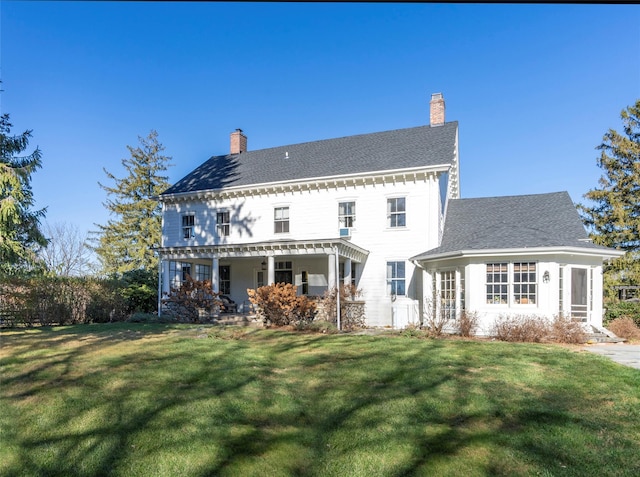 rear view of house featuring a lawn