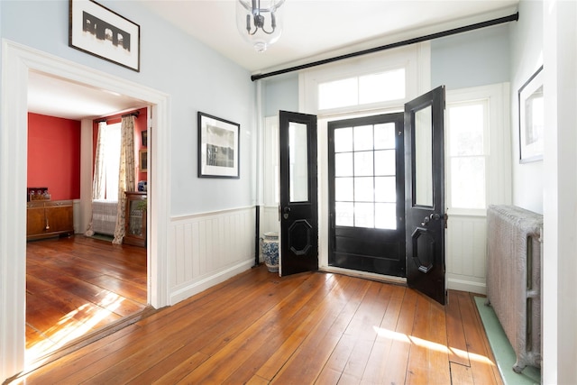 entrance foyer with plenty of natural light, wood-type flooring, and radiator heating unit