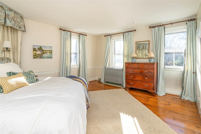 bedroom with radiator heating unit and light hardwood / wood-style floors