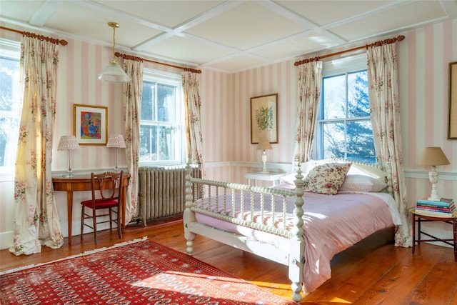 bedroom with radiator heating unit, coffered ceiling, and wood-type flooring