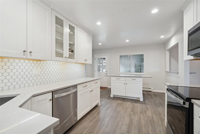 kitchen with a baseboard radiator, stainless steel appliances, decorative backsplash, light hardwood / wood-style floors, and white cabinetry