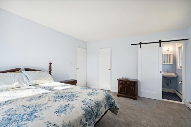 bedroom featuring carpet, sink, a baseboard heating unit, and a barn door