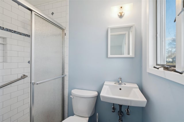 bathroom with sink, toilet, and an enclosed shower