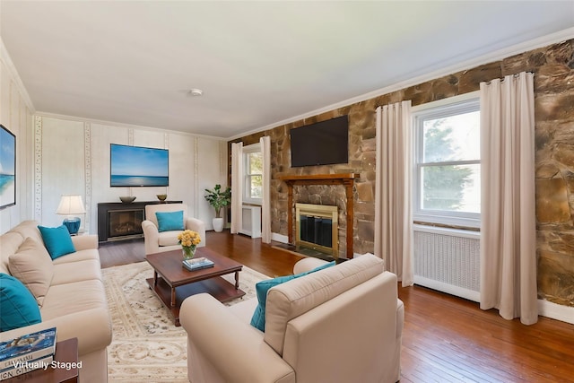 living area with hardwood / wood-style flooring, a fireplace, and ornamental molding