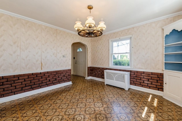 interior space with radiator heating unit, a chandelier, arched walkways, baseboards, and ornamental molding