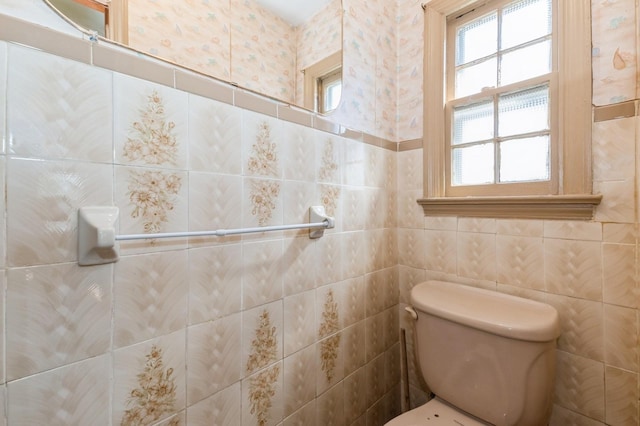 bathroom with tile walls and toilet