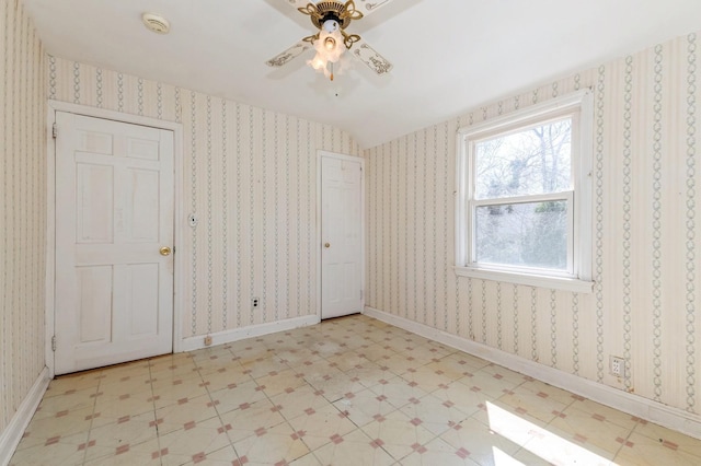 empty room with light floors and a ceiling fan