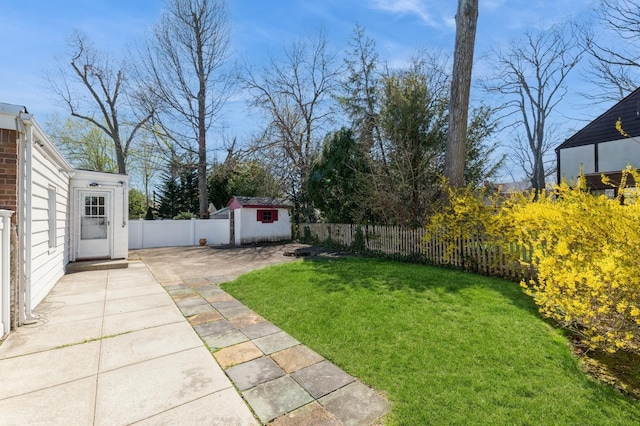 view of yard with a fenced backyard, an outdoor structure, a patio area, and a storage shed