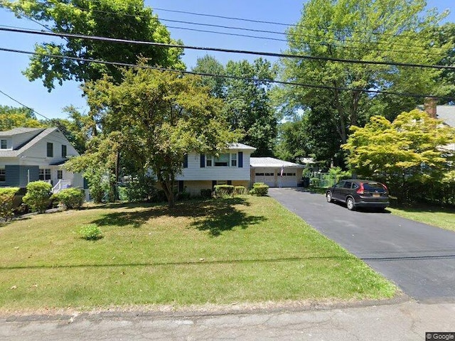 view of front of home with a garage and a front lawn