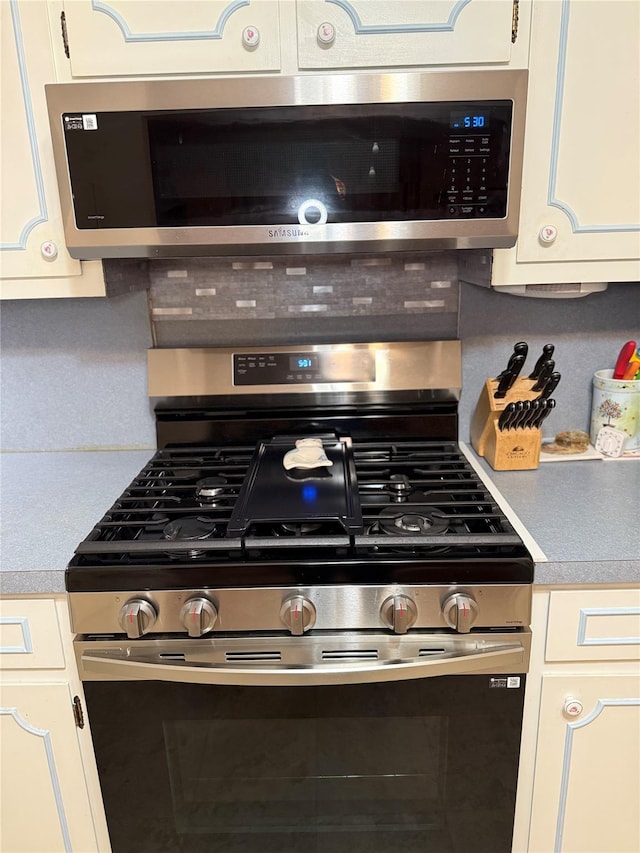 kitchen featuring appliances with stainless steel finishes, light countertops, and white cabinetry