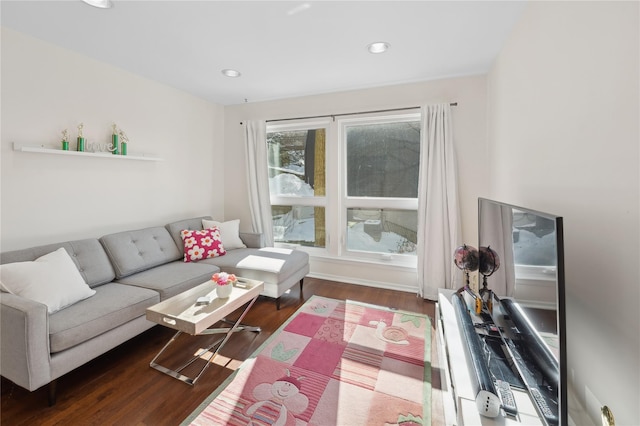 living area with dark wood-style flooring and recessed lighting