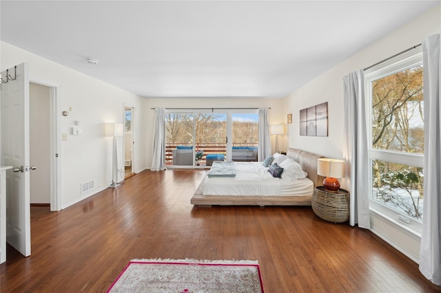 bedroom featuring access to outside, visible vents, dark wood finished floors, and baseboards