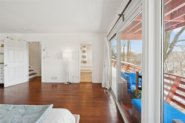 bedroom with access to exterior, visible vents, dark wood finished floors, and baseboards