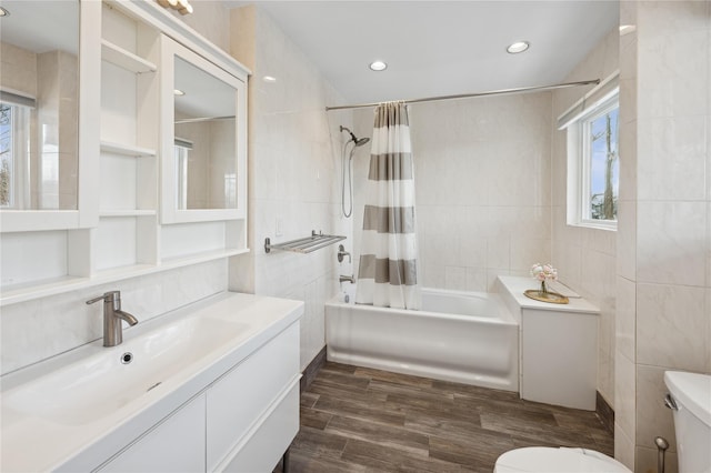 bathroom with tile walls, toilet, shower / bath combo, vanity, and wood finished floors