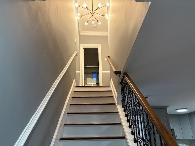 staircase featuring an inviting chandelier