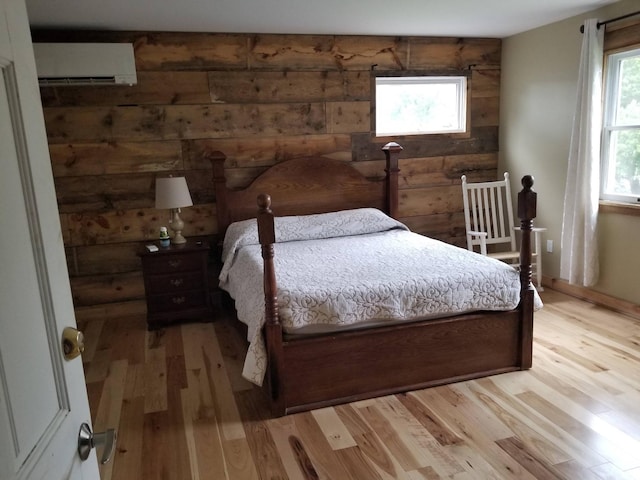 888 Pondview Rd, Riverhead, NY 11901 - bedroom featuring a wall mounted air conditioner, light hardwood / wood-style floors, and wood walls